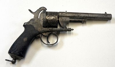 un vieux fusil sur une surface blanche avec un fond blanc