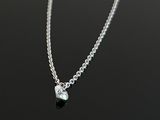 a close up of a silver necklace with a heart on it