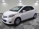 une photo d'une toyota yaris blanche garée sur un sol en damier
