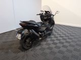 a black motorcycle parked in a room with a checkered floor