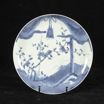 a blue and white plate with a bird and flowers on it