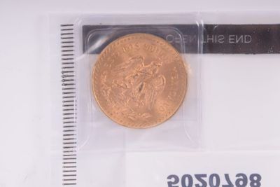 a gold coin in a plastic bag with a ruler