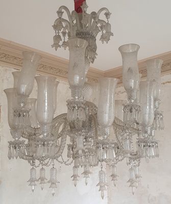 a chandelier that has a red rose on top of it