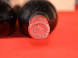two bottles of wine sitting on a red table