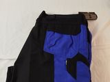 blue and black pants laying on a bed with a white sheet