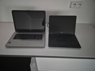two laptops that are sitting on a white table