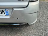 the rear end of a silver car with a number plate on it