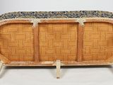 an image of a wicker couch with a blue and gold cover