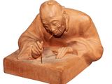 statue représentant un homme en train d'écrire sur une feuille de papier avec un stylo