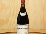 a bottle of wine sitting on top of a wooden barrel