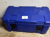 une boîte à outils bleue posée par terre devant un mur
