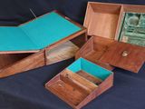 three wooden boxes with a turquoise cover are sitting on a black surface