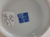 a white vase with a blue and white label on it