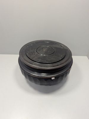a black bowl with a lid on a white table