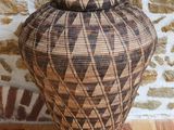 une photo d'un vase tressé posé sur une table en bois