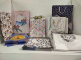 de nombreux sacs en papier posés sur une table, à côté d'un ventilateur