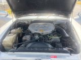 une photo d'une voiture dont le capot est ouvert, laissant apparaître le moteur