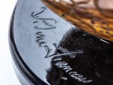 a glass bowl sitting on top of a black plate