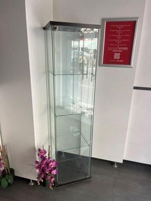 une vitrine en verre dans le coin d'une pièce