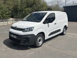 Une camionnette Citroën garée sur un parking, avec des arbres en arrière-plan