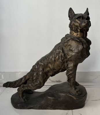 une statue représentant un chien assis sur un rocher