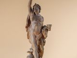 statue of a woman holding a bird on a wooden base