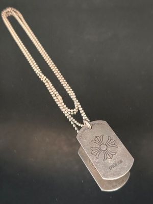 une plaque d'identité en argent sur laquelle est gravée une fleur