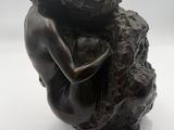 statue d'une femme serrant un rocher dans ses bras, sur fond blanc