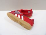 red and white adidas sneakers on a white surface