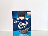 a box of cereal sitting on a table next to a cup of coffee