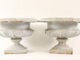 two white vases sitting next to each other on a white surface