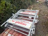 une pile de panneaux « Pletac » posée sur le bord de la route