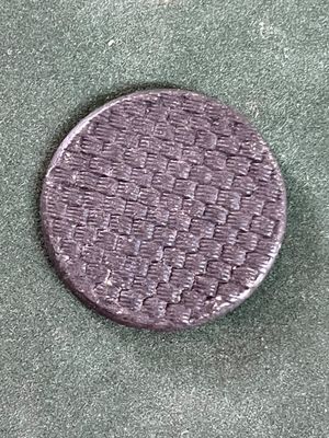 un gros plan d'un bouton violet sur une surface verte