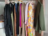 a clothes rack with clothes hanging on it in a room