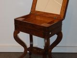 a small wooden table with a mirror on top of it