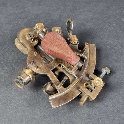 an old brass sexet with a wooden handle on a gray surface