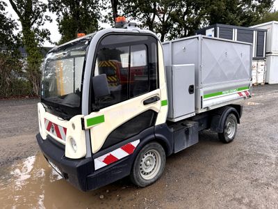 un petit camion garé sur un terrain en terre battue