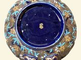 a blue and gold vase with a handle on a white background