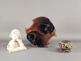 trois vases et une statue d'enfant posés sur une table