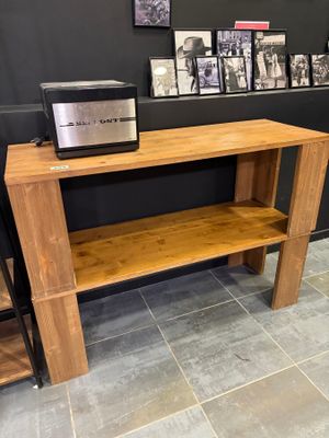 a wooden table with a microwave on top of it