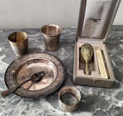 un plateau en argent avec des cuillères et un repose-cuillères posé sur une table en marbre