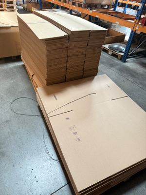 several stacks of cardboard are stacked on top of each other in a warehouse