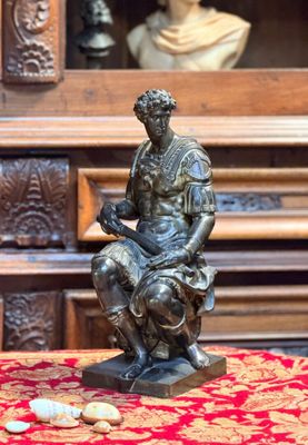 une statue d'un homme assis sur une table