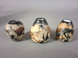 three vases with different designs on them sitting on a table