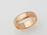a gold wedding ring on a white background