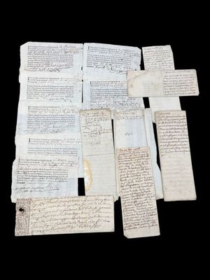 several old papers are stacked on top of each other on a black surface