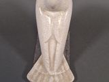 a white vase with a bird on it on a table