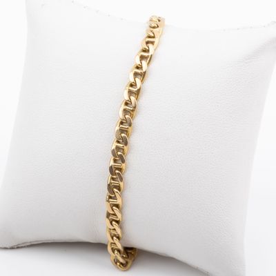 a close up of a gold chain bracelet on a pillow