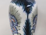 a blue and white vase sitting on a white surface
