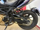 a black motorcycle parked in a garage with a red and white wall